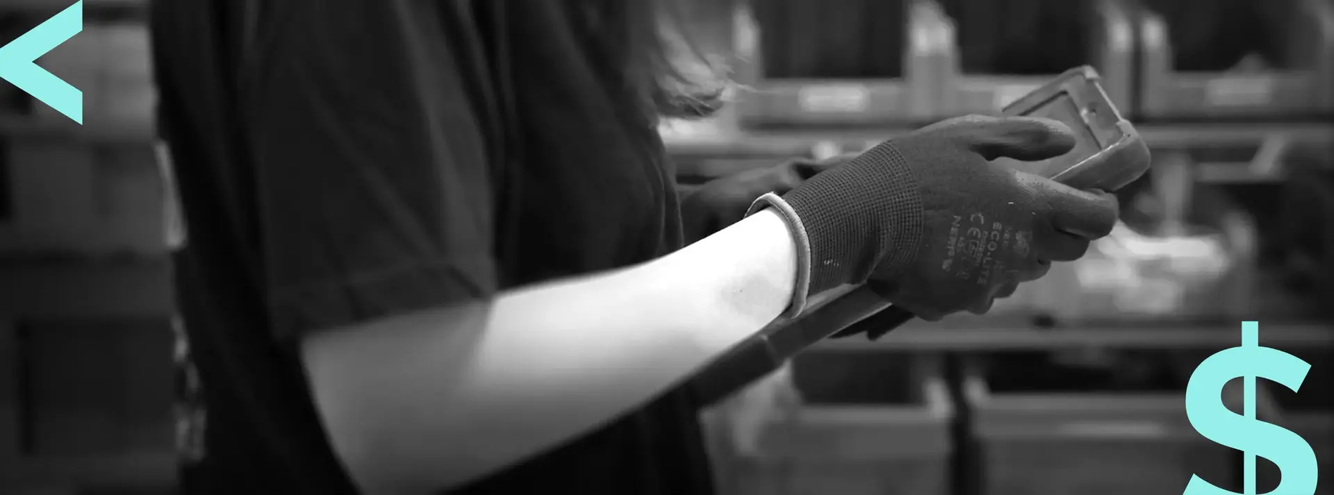 Operatrice con guanti da lavoro consulta un terminalino portatile in magazzino